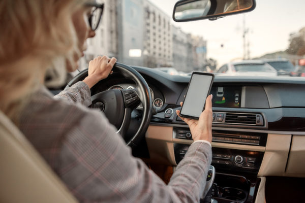 Woman looking at phone while driving